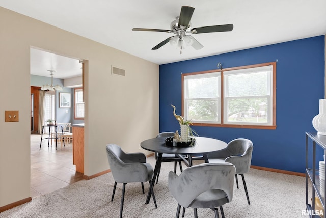505 N 7th St, Eldridge, IA 52748 - dining space featuring ceiling fan, a chandelier, light colored carpet, and light tile patterned floors
