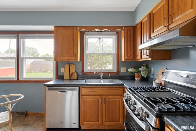 505 N 7th St, Eldridge, IA 52748 - kitchen featuring stainless steel appliances, dark countertops, under cabinet range hood, and brown cabinets