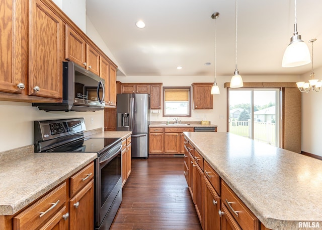 95 N 18th St, Clinton, IA 52732 - kitchen with stainless steel appliances, brown cabinetry, dark wood finished floors, pendant lighting, and recessed lighting