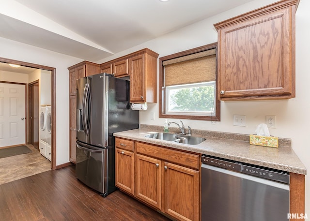 95 N 18th St, Clinton, IA 52732 - kitchen featuring appliances with stainless steel finishes, washing machine and clothes dryer, dark wood finished floors, brown cabinets, and vaulted ceiling