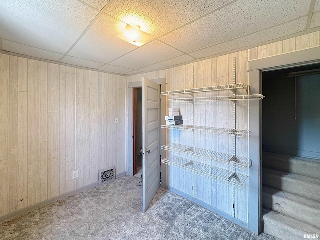 1426 32nd St, Rock Island, IL 61201 - unfurnished bedroom featuring wooden walls, a paneled ceiling, and carpet