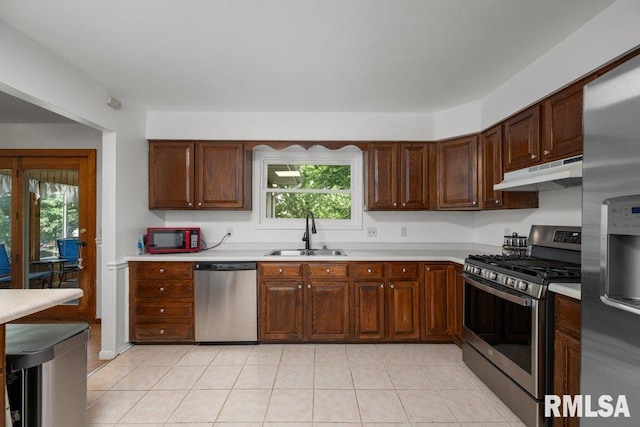 2917 W 65th St, Davenport, IA 52806 - kitchen with appliances with stainless steel finishes, under cabinet range hood, light countertops, and plenty of natural light