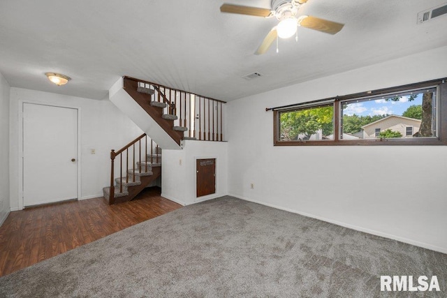 2917 W 65th St, Davenport, IA 52806 - unfurnished living room featuring stairs, a ceiling fan, wood finished floors, and carpet