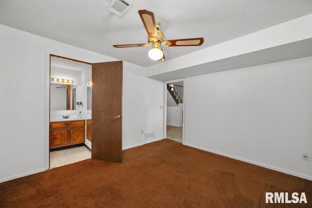 2917 W 65th St, Davenport, IA 52806 - unfurnished bedroom with light carpet, ensuite bath, and a ceiling fan