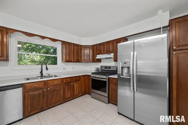 2917 W 65th St, Davenport, IA 52806 - kitchen with appliances with stainless steel finishes, light countertops, under cabinet range hood, and light tile patterned floors