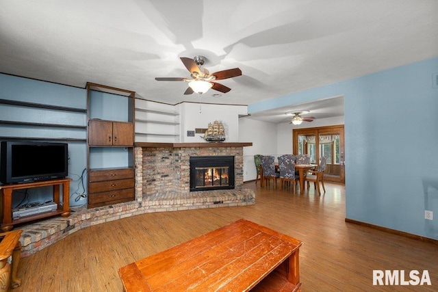 2917 W 65th St, Davenport, IA 52806 - living area featuring a ceiling fan, wood finished floors, and a fireplace