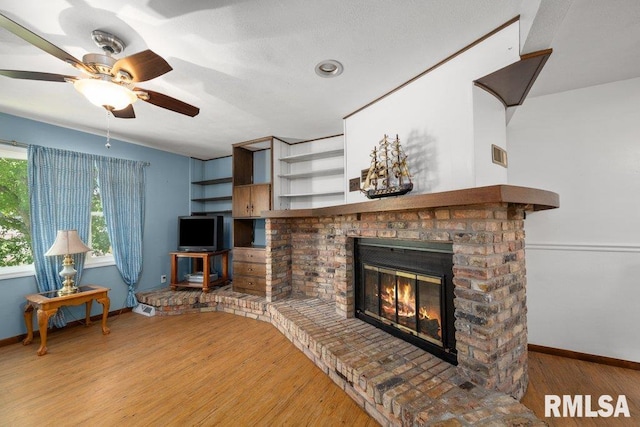 2917 W 65th St, Davenport, IA 52806 - living room featuring a ceiling fan, wood finished floors, and a fireplace