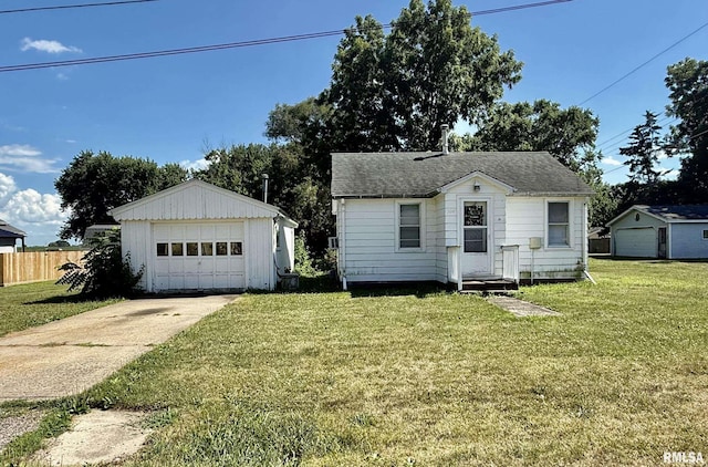 304 E Ames St, Yates City, IL 61572 - bungalow featuring a garage, an outdoor structure, a shingled roof, and driveway