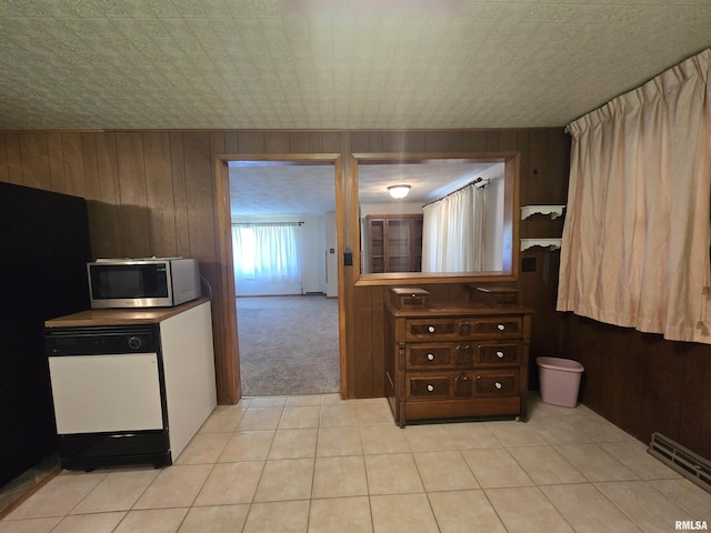 507 S Church St, Albany, IL 61230 - interior space with stainless steel microwave, white dishwasher, wooden walls, light carpet, and light tile patterned floors