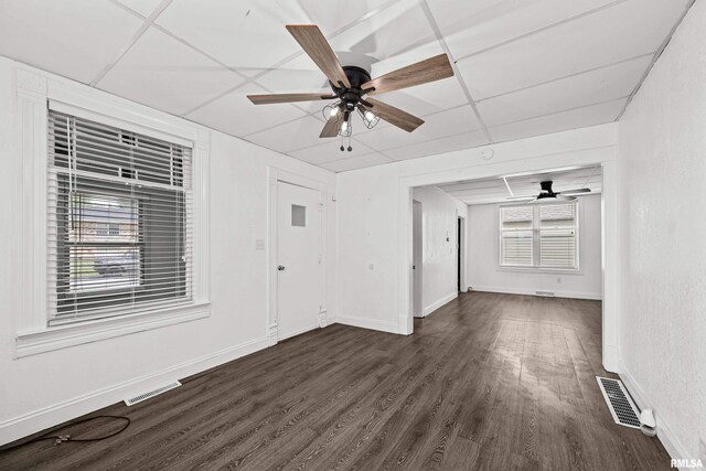 404 5th St, Sherrard, IL 61281 - empty room featuring ceiling fan, dark wood-type flooring, and a drop ceiling