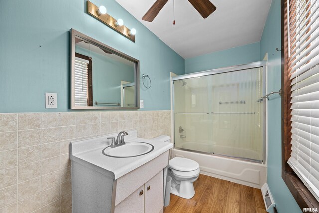 404 5th St, Sherrard, IL 61281 - full bath featuring vanity, tile walls, ceiling fan, enclosed tub / shower combo, and wood finished floors
