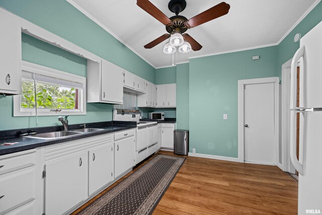 404 5th St, Sherrard, IL 61281 - kitchen featuring white appliances, dark countertops, crown molding, white cabinets, and wood finished floors