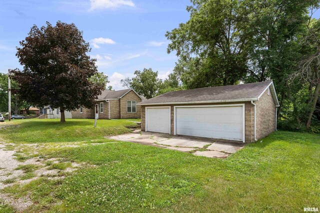 404 5th St, Sherrard, IL 61281 - view of front of property with a garage, brick siding, a front yard, and an outdoor structure