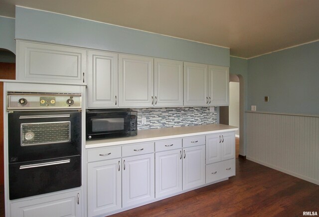 1524 W 4th St, Milan, IL 61264 - kitchen featuring black appliances, arched walkways, dark wood-style floors, a wainscoted wall, and white cabinets