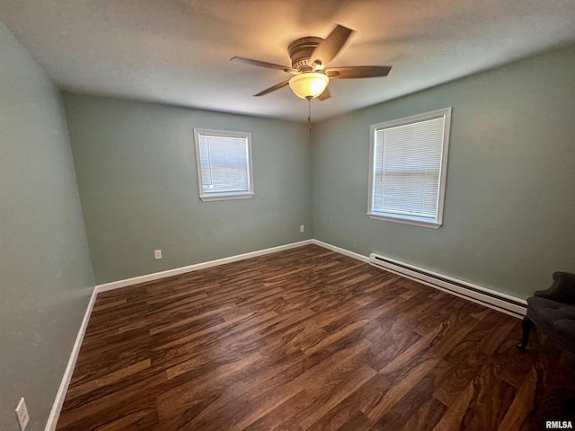 202 S 10th Ave, New Windsor, IL 61465 - unfurnished room featuring a baseboard heating unit, dark wood-style floors, and a ceiling fan