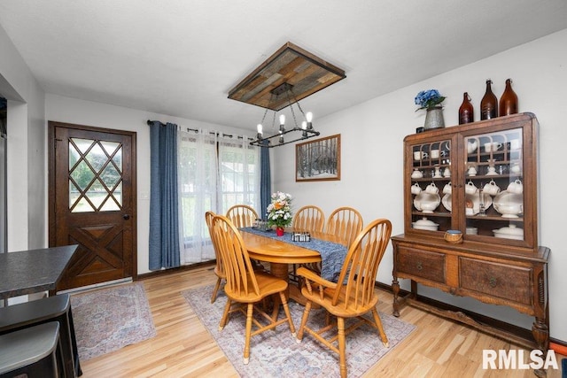 833 Robin Rd, Muscatine, IA 52761 - dining space featuring a chandelier, healthy amount of natural light, and light wood-type flooring