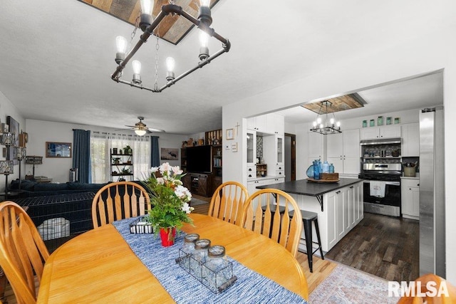 833 Robin Rd, Muscatine, IA 52761 - dining area with a chandelier, dark wood-type flooring, and a ceiling fan