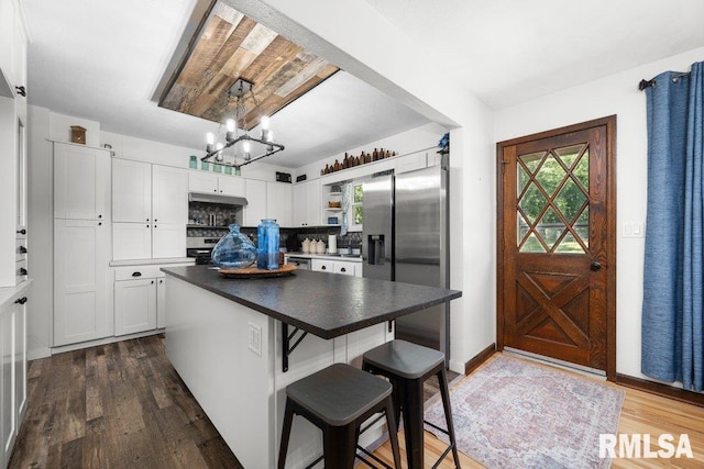 833 Robin Rd, Muscatine, IA 52761 - kitchen featuring open shelves, appliances with stainless steel finishes, dark wood-style floors, white cabinetry, and a kitchen bar