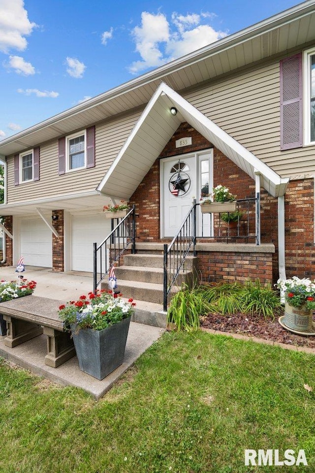 833 Robin Rd, Muscatine, IA 52761 - view of front of house featuring brick siding, an attached garage, and driveway