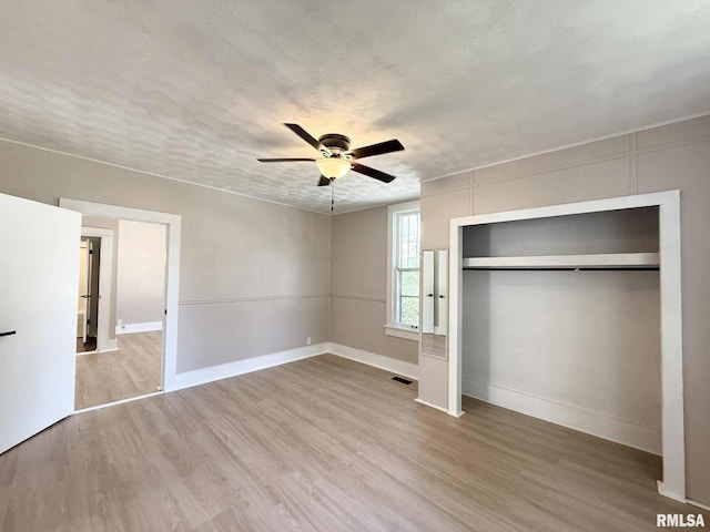 2111 Pine St, Murphysboro, IL 62966 - unfurnished bedroom with wood finished floors, a closet, and a ceiling fan