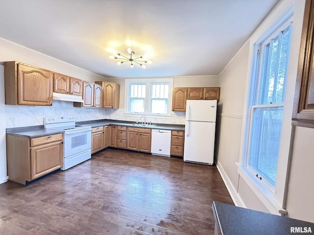 2111 Pine St, Murphysboro, IL 62966 - kitchen featuring white appliances, under cabinet range hood, a chandelier, dark countertops, and tasteful backsplash
