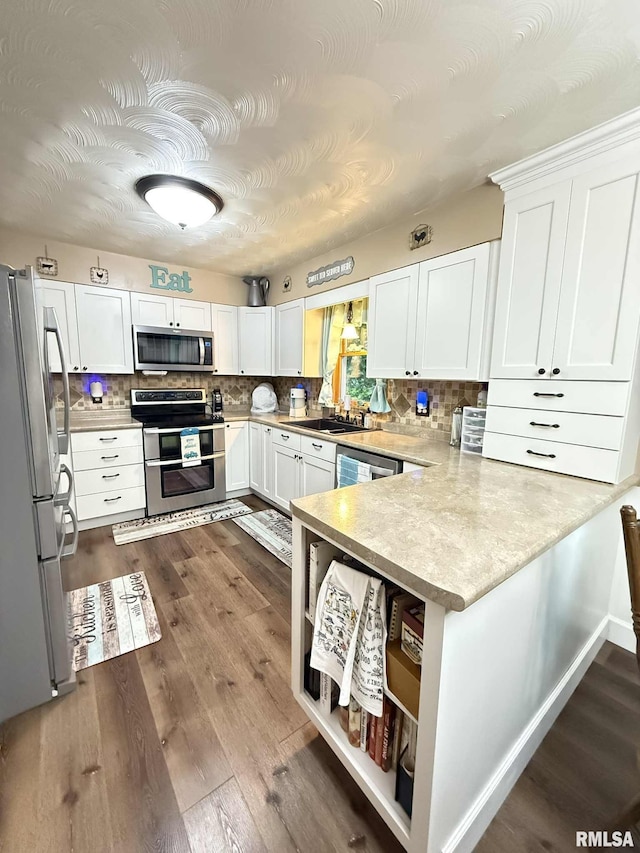 501 N Cambridge Dr, Desoto, IL 62924 - kitchen featuring appliances with stainless steel finishes, a peninsula, white cabinetry, and decorative backsplash