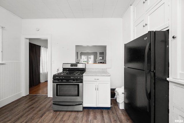1207 N Marquette St, Davenport, IA 52804 - kitchen featuring freestanding refrigerator, stainless steel range with gas cooktop, dark wood-type flooring, ornamental molding, and white cabinetry