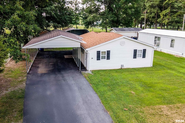 1904 E D St, West Frankfort, IL 62896 - view of front of property with a carport, asphalt driveway, a front yard, a shingled roof, and view of wooded area