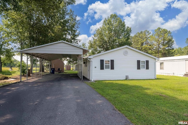 1904 E D St, West Frankfort, IL 62896 - view of front of home with a detached carport, driveway, a front yard, and a storage unit