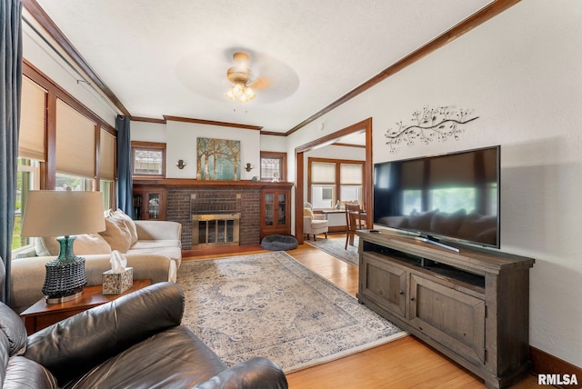 517 E 29th Pl, Davenport, IA 52803 - living room with ceiling fan, light wood-style floors, ornamental molding, and a brick fireplace