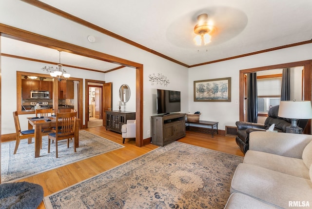 517 E 29th Pl, Davenport, IA 52803 - living area featuring light wood finished floors, a chandelier, crown molding, and a ceiling fan