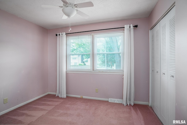 4718 19th Ave, Moline, IL 61265 - unfurnished bedroom featuring light carpet, a closet, a textured ceiling, and ceiling fan