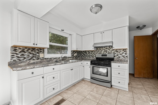 2525 4th St Unit A, East Moline, IL 61244 - kitchen with stainless steel gas range oven, under cabinet range hood, white cabinets, and backsplash
