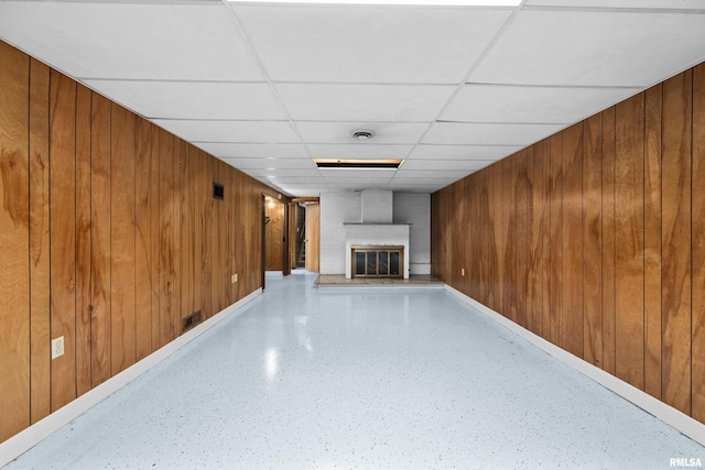 2525 4th St Unit A, East Moline, IL 61244 - unfurnished living room featuring a brick fireplace, a drop ceiling, wood walls, and speckled floor