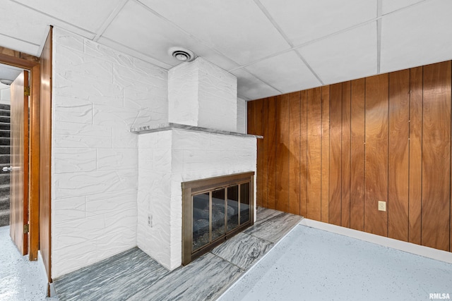 2525 4th St Unit A, East Moline, IL 61244 - unfurnished living room featuring stairs, wood walls, and a brick fireplace