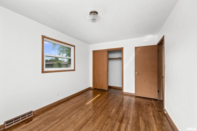 2525 4th St Unit A, East Moline, IL 61244 - unfurnished bedroom with dark wood-style flooring and a closet