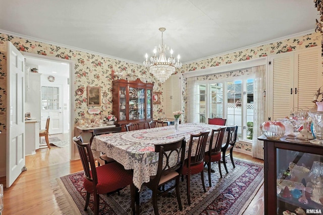 1928 Fernwood Ave, Davenport, IA 52803 - dining room with crown molding, a chandelier, light wood-type flooring, and wallpapered walls
