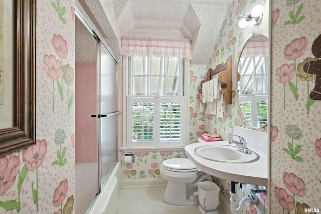 1928 Fernwood Ave, Davenport, IA 52803 - bathroom with wallpapered walls, vaulted ceiling, plenty of natural light, and combined bath / shower with glass door