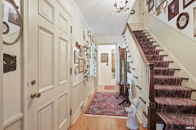 1928 Fernwood Ave, Davenport, IA 52803 - foyer featuring stairway, light wood finished floors, crown molding, and a chandelier