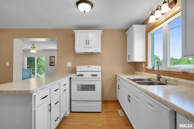 304 E Plum St, Anamosa, IA 52205 - kitchen with white appliances, under cabinet range hood, a peninsula, light wood-type flooring, and light countertops