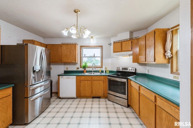335 Sand Aly, Toronto, IA 52777 - kitchen featuring stainless steel appliances, light floors, brown cabinets, and under cabinet range hood