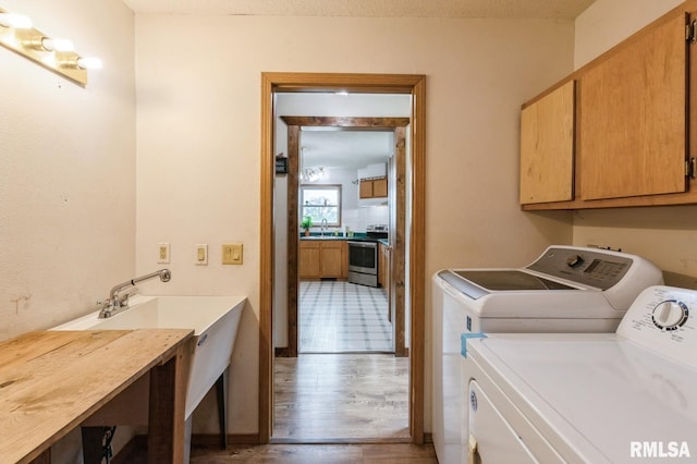 335 Sand Aly, Toronto, IA 52777 - washroom featuring cabinet space, washing machine and clothes dryer, and wood finished floors