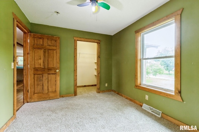 335 Sand Aly, Toronto, IA 52777 - unfurnished bedroom featuring carpet flooring, a spacious closet, and a ceiling fan