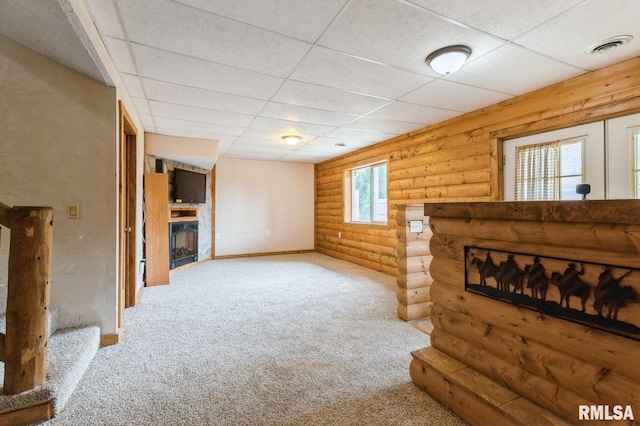 335 Sand Aly, Toronto, IA 52777 - unfurnished living room with log walls, a large fireplace, carpet floors, and a paneled ceiling