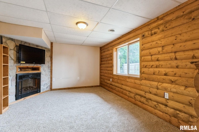 335 Sand Aly, Toronto, IA 52777 - unfurnished living room featuring rustic walls, a large fireplace, a paneled ceiling, and carpet
