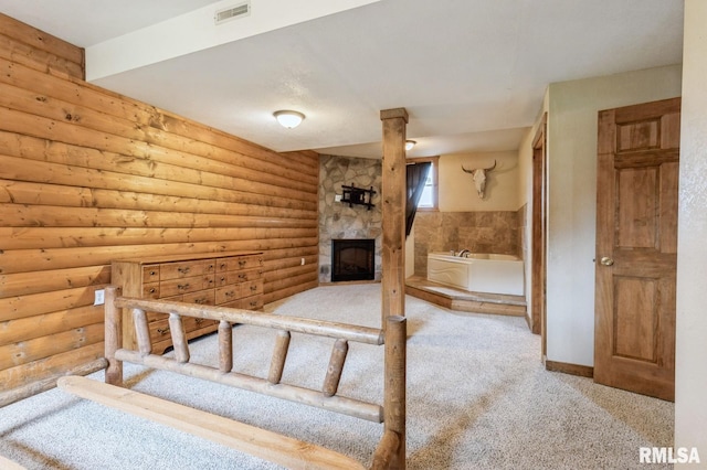 335 Sand Aly, Toronto, IA 52777 - unfurnished bedroom featuring carpet, a fireplace, and rustic walls