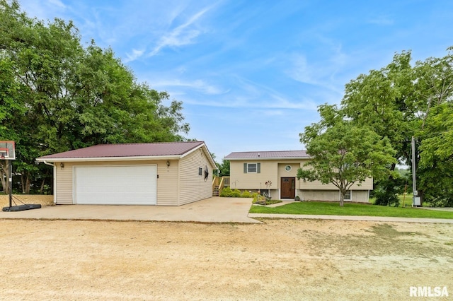 335 Sand Aly, Toronto, IA 52777 - raised ranch featuring an outbuilding, a metal roof, and a garage