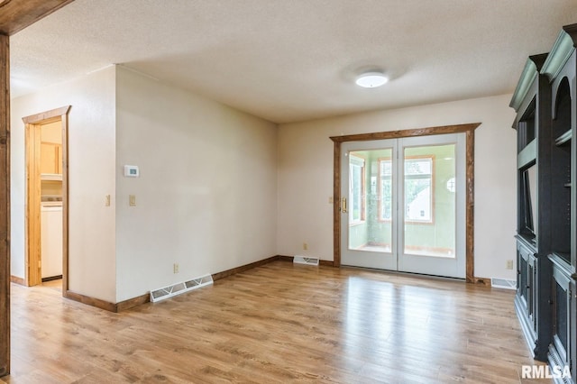 335 Sand Aly, Toronto, IA 52777 - unfurnished living room featuring light wood finished floors and a textured ceiling