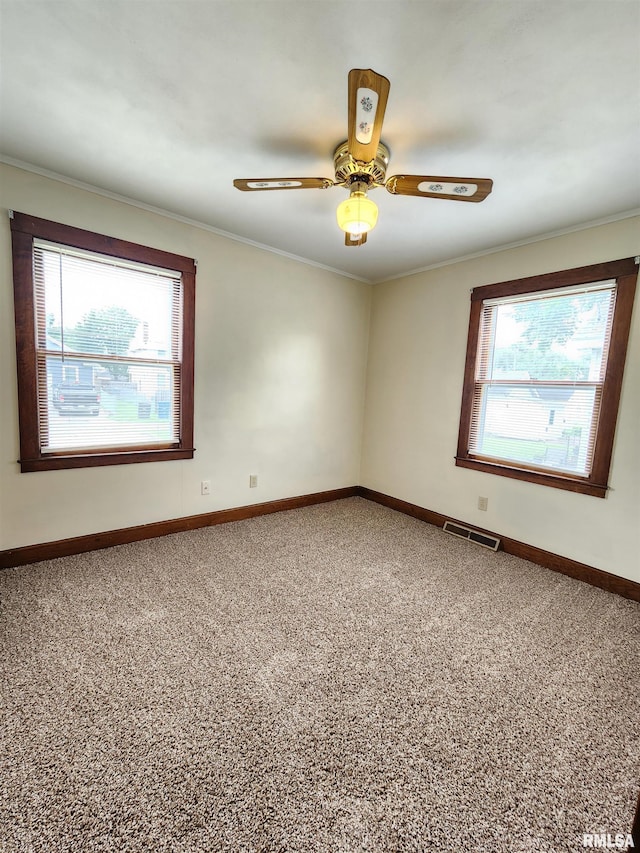 1908 24th St, Moline, IL 61265 - empty room featuring plenty of natural light, carpet floors, ornamental molding, and ceiling fan