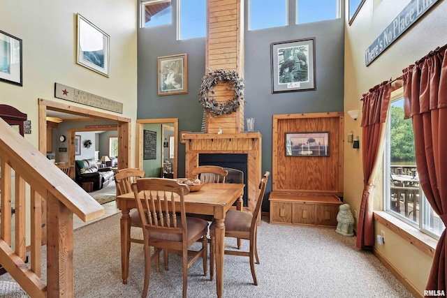 18599 317th St, Long Grove, IA 52756 - dining area featuring a high ceiling, carpet floors, and a fireplace